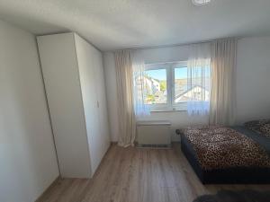 ein Schlafzimmer mit einem Bett und einem großen Fenster in der Unterkunft Ferienwohnungen Weinbergglück in Lauda-Königshofen