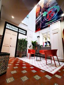 a room with red chairs and a table on a rug at Feel Hostels City Center in Málaga