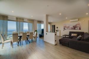 a living room with a couch and a table and chairs at Luxury Liam Villa with Pool and Sea View - Goelba in Portoferraio