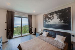 a bedroom with a bed and a large painting on the wall at Luxury Liam Villa with Pool and Sea View - Goelba in Portoferraio +50 photos