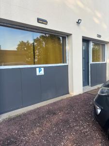 a blue garage door with a parking sign on it at L'Ambréenne in Sainte-Cécile