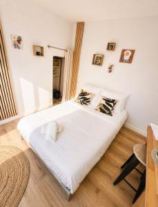 a bedroom with a large white bed in a room at Le Petit Jean Alexandre – Studio centre-ville in Poitiers
