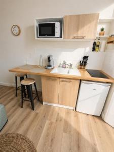 a small kitchen with a sink and a microwave at Le Petit Jean Alexandre – Studio centre-ville in Poitiers