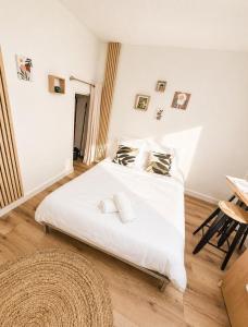 a bedroom with a bed with white sheets and pillows at Le Petit Jean Alexandre – Studio centre-ville in Poitiers +2 photos