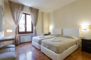 フィレンツェにあるLe Por Santa Mariaのベッドルーム1室(ベッド2台、窓付)