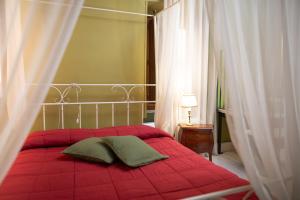 a red bed with two pillows on it in a bedroom at Palazzo Riario in Viterbo