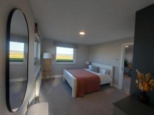 a bedroom with a bed and a large mirror at Sunny Hill View in Lahinch