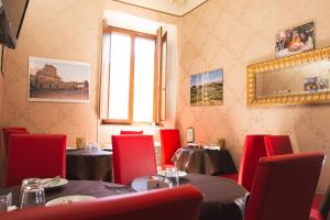a restaurant with tables and red chairs and a window at Palazzo Riario in Viterbo