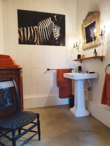 a bathroom with a sink and a zebra painting on the wall at Gîte La Tour du Moulin in Saint-Étienne-de-Montluc