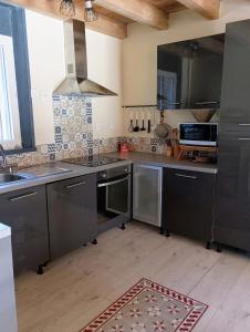 a kitchen with stainless steel appliances and a sink at Chalet lac Celinda in Saint-Mamet