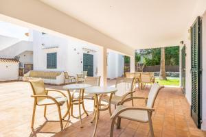 a patio with tables and chairs and a couch at Apartamento Felipe 2-1 in Cacla D'or