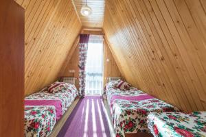 two beds in a room with wooden walls and a window at Willa Stachoniówka 2 in Zakopane +67 photos