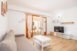 a living room with a couch and a tv and a table at Apartamento Felipe 2-1 in Cacla D'or