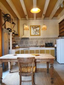a kitchen with a wooden table and a refrigerator at Gîte La Tour du Moulin in Saint-Étienne-de-Montluc +40 photos