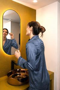 a woman brushing her teeth in front of a mirror at Hotel Moderno in Bari +34 photos