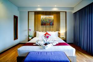 a hotel room with a bed with two towels on it at The Kirana Canggu Hotel in Canggu