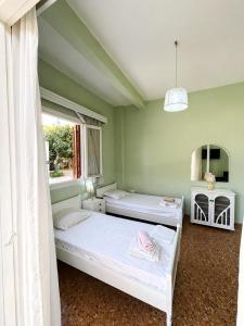 a bedroom with two beds and a window at Konstantinou Apartments in Paralio Astros