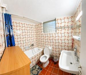 a bathroom with a toilet and a tub and a sink at Konstantinou Apartments in Paralio Astros