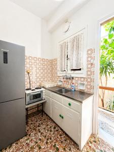 a kitchen with a sink and a refrigerator at Konstantinou Apartments in Paralio Astros