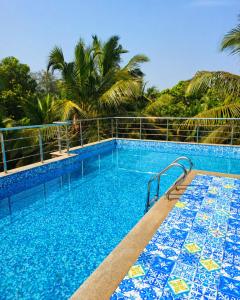 a swimming pool with blue and white tiles on it at Hotel bright house in Calangute