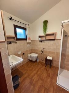 a bathroom with a toilet and a sink at Oasi Muru Idda in Budoni +63 photos