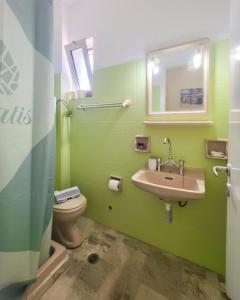 a green bathroom with a sink and a toilet at Vassia's B rooms in Poros +63 photos