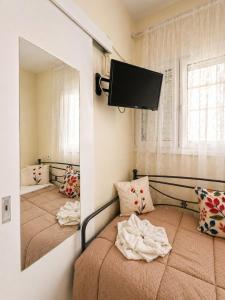 a bedroom with two beds and a mirror at Vassia's B rooms in Poros