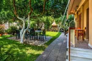 a garden with a table and chairs and a playground at Konstantinou Apartments in Paralio Astros +14 photos