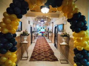 a corridor with black and yellow balloons and a hallway lined with tables at Shri Mangal Palace in Gwalior