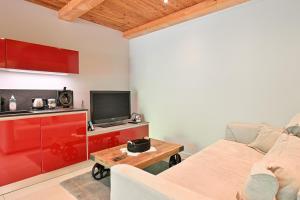 a living room with a couch and a tv at Appartement Alice - Dans chalet in Les Villards-sur-Thônes
