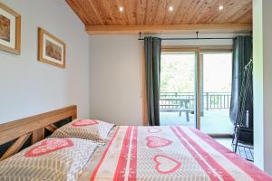 a bedroom with a bed and a balcony at Appartement Alice - Dans chalet in Les Villards-sur-Thônes