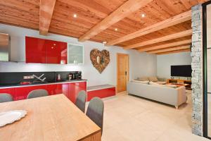 a kitchen and living room with a wooden ceiling at Appartement Lisa - Dans chalet in Les Villards-sur-Thônes