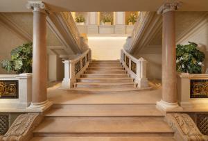a staircase in a building with columns and plants at EST Hotel Palais Chotek NEW OPENING in Vienna