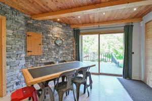 a ping pong table in a room with a stone wall at Appartement Alice - Dans chalet in Les Villards-sur-Thônes