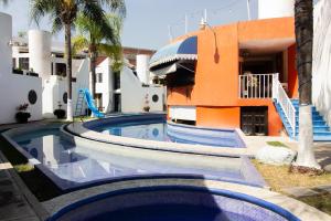 ein Schwimmbad mit Rutsche vor einem Gebäude in der Unterkunft Capital O Hotel Partidor Del Sol, Oaxtepec in Oaxtepec