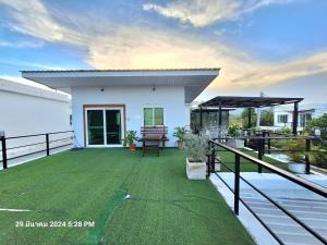 a patio with green grass and a house at Plus 1 2 3 Hua-Hin Private Poolvilla from beach 3km in Hua Hin