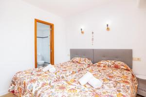 a bedroom with a bed with a colorful bedspread at Apartamento Felipe 2-3 in Cacla D'or +18 photos