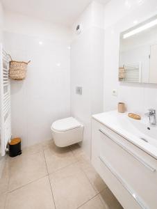 a white bathroom with a toilet and a sink at Appartement Terrasse St Florent in Saint-Florent +6 photos