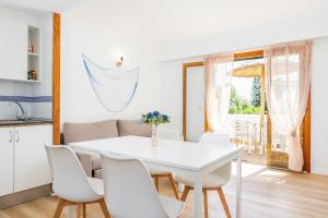 a white dining room with a white table and chairs at Apartamento Felipe 2-3 in Cacla D'or
