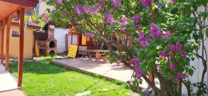 a tree with purple flowers next to a house at Pension Casa Leone in Timişoara