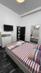 a bedroom with a large bed and a tv at Royal Suite in Odesa