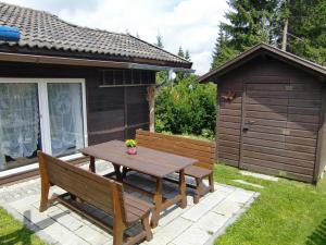 a picnic table and a bench in a yard at Ferienhaus Altenstrasser in Philippsreut