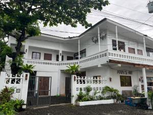 a white house with a gate in front of it at Ann's Place in Cabangan