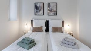 a white bed with two pillows on top of it at Sali Homes - Opera Loge 2BR Balcony in Bayreuth