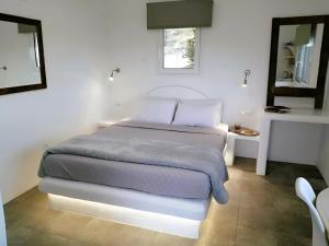 a bed in a white room with a window at Filia Bungalow in Archangelos +23 photos