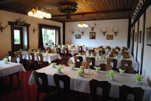 ein Bankettraum mit Tischen und Stühlen mit weißen Tischdecken in der Unterkunft Hotel Ruhekrug in Schleswig