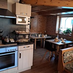 a kitchen with a stove and some tables in it at Grünwaldhof in Tux