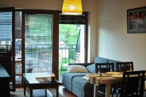 een woonkamer met een blauwe bank en een tafel bij Zakopane - Apartament z widokiem in Zakopane