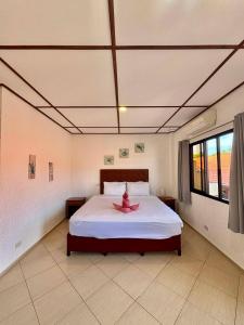a bedroom with a bed with a pink bow on it at Sunville Hotel and Restaurant in Panglao Island