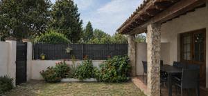 a patio with a table and a fence with flowers at Chalet con jardin cerca de la playa in Can Pastilla